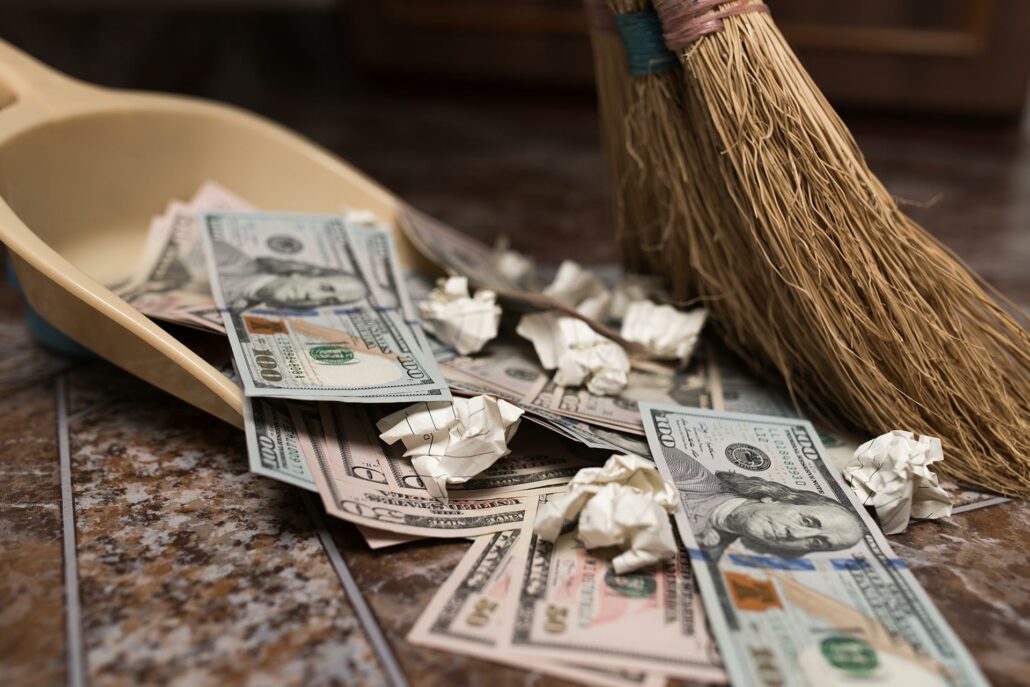 Money being swept up with paper trash